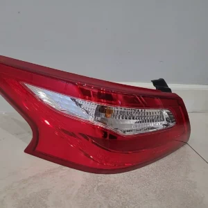 A red tail light on the side of a car.