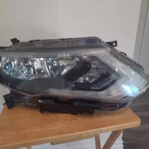 A car headlight sitting on top of a wooden table.