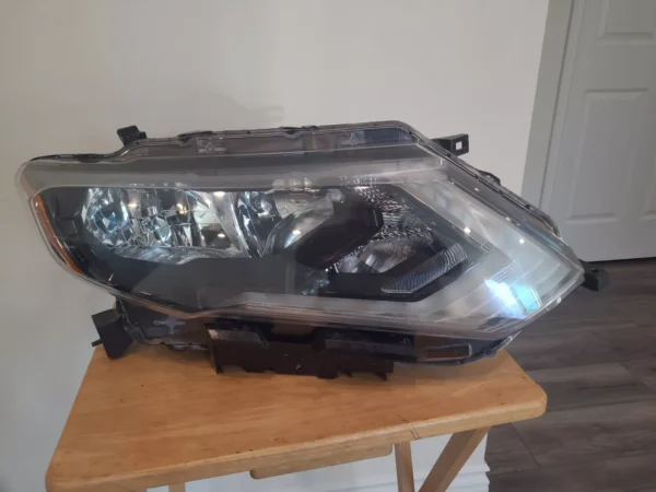 A car headlight sitting on top of a wooden table.