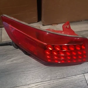 A red tail light sitting on the ground.