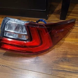 A red and white car tail light on the floor