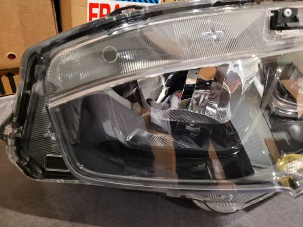 A car headlight with its reflection of the lights.