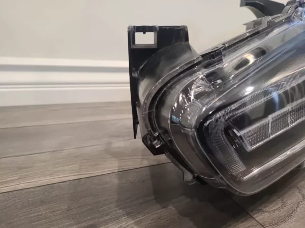 A car headlight is bent over on the floor.