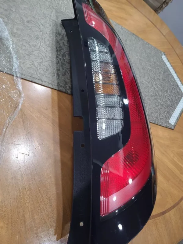 A red and black car tail light on top of a table.