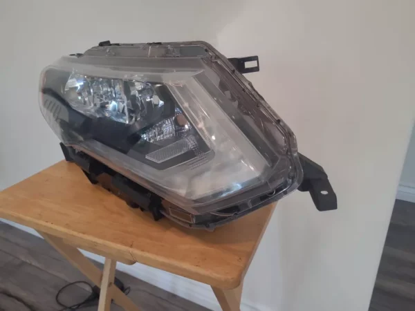 A car headlight sitting on top of a wooden table.