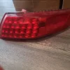 A red tail light sitting on top of a wooden floor.