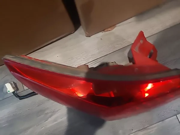 A red skateboard with lights on the bottom of it.