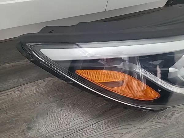 A car headlight on the floor of a room.