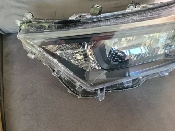 A car headlight that is wrapped in plastic.