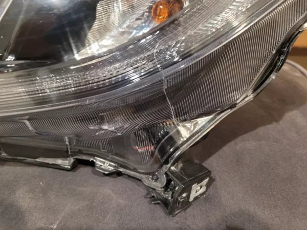 A car headlight with the hood up.