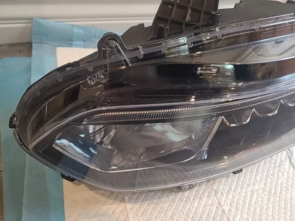 A car headlight with the hood open.