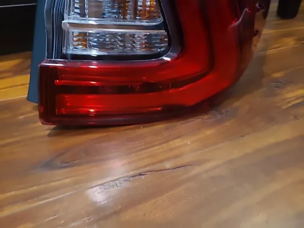 A red and white tail light on the side of a car.