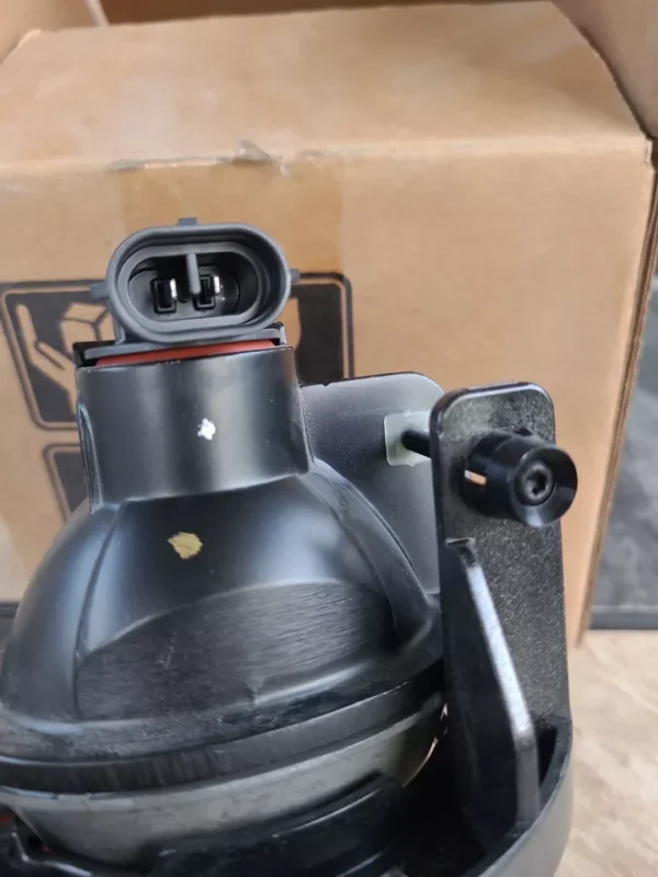 A black gas tank sitting next to a box.