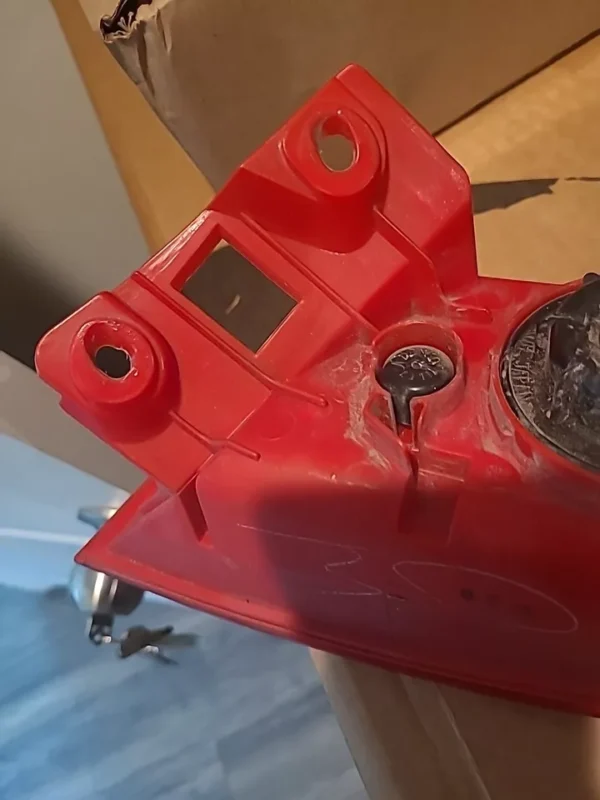 A red gas tank sitting on top of a wooden floor.