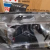 A car headlight with the lights on and some other items in it