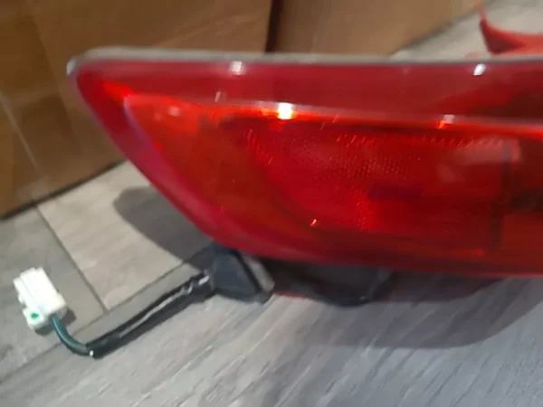 A red tail light on the side of a car.