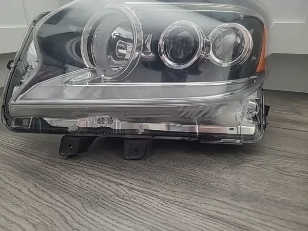 A car 's headlight is shown with the front of it.