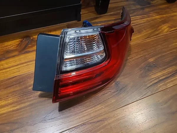 A red and white car tail light on the floor