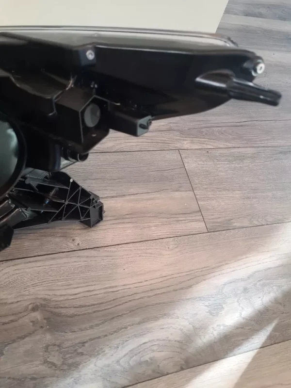 A motorcycle is parked on the ground in front of a wooden floor.