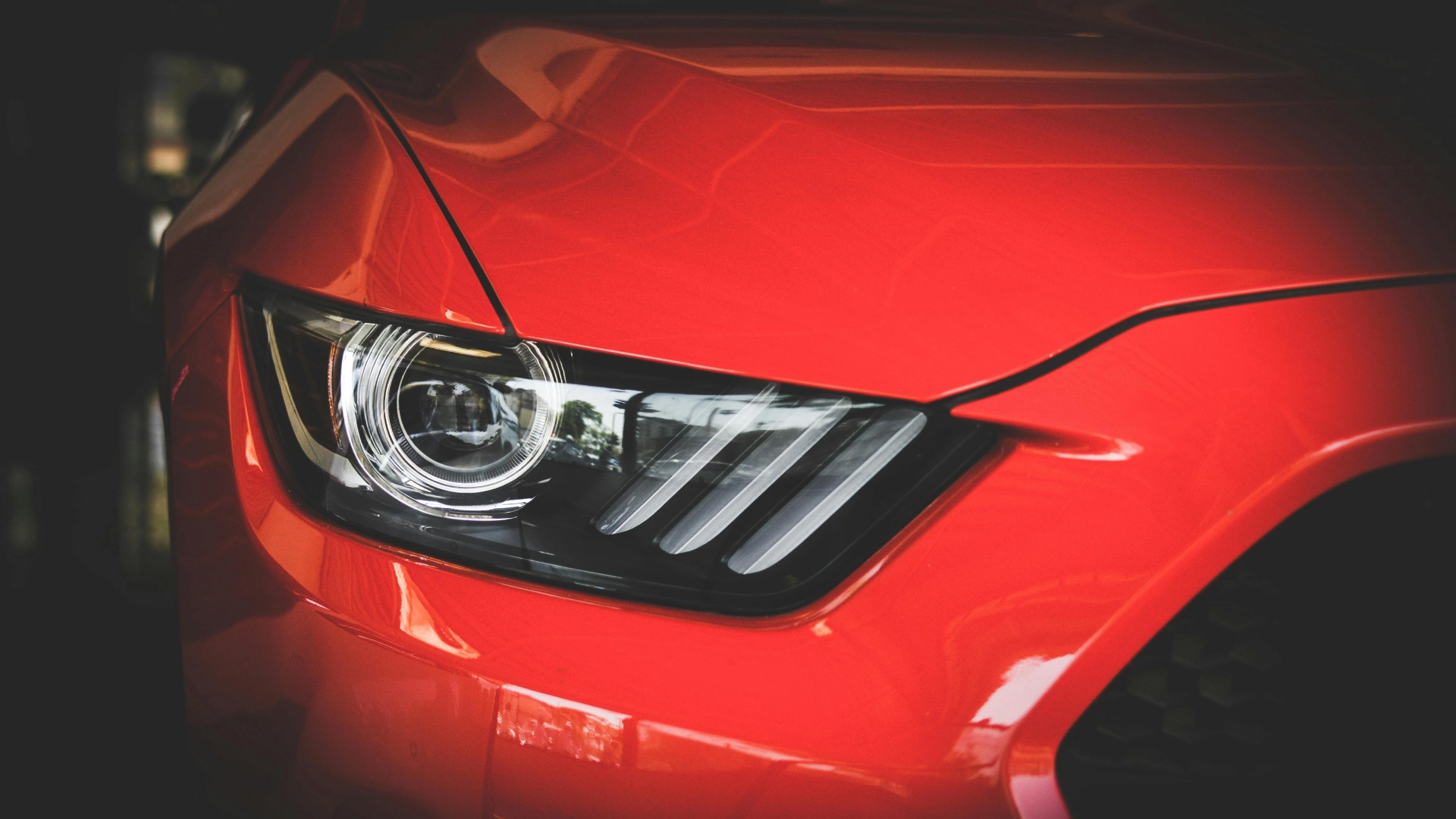 A close up of the headlight on a red car