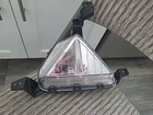 Triangular car headlight with clear lens and mounting brackets.