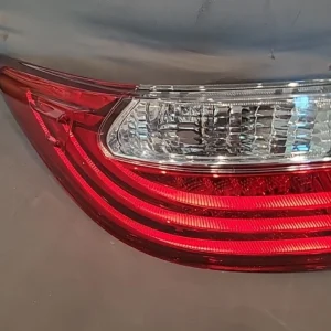 Close-up of a red and clear car tail light on a gray vehicle.