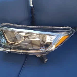 Car headlight assembly placed on a blue surface.