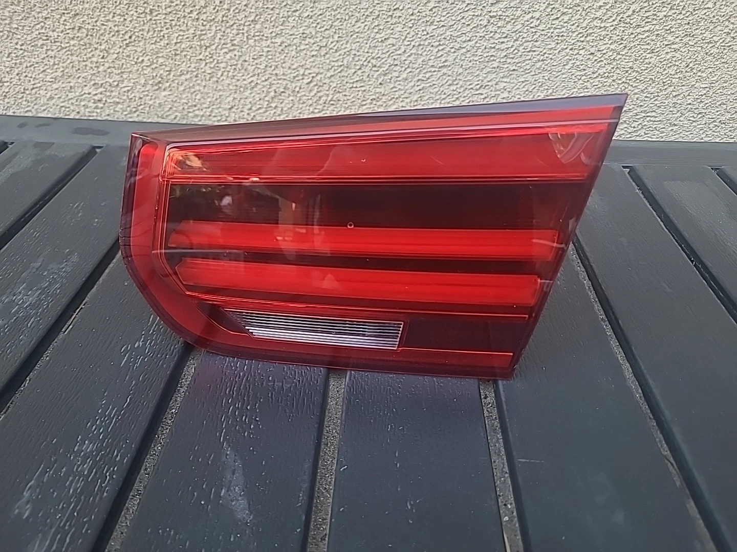 Close-up of a red car taillight with distinct horizontal lines.