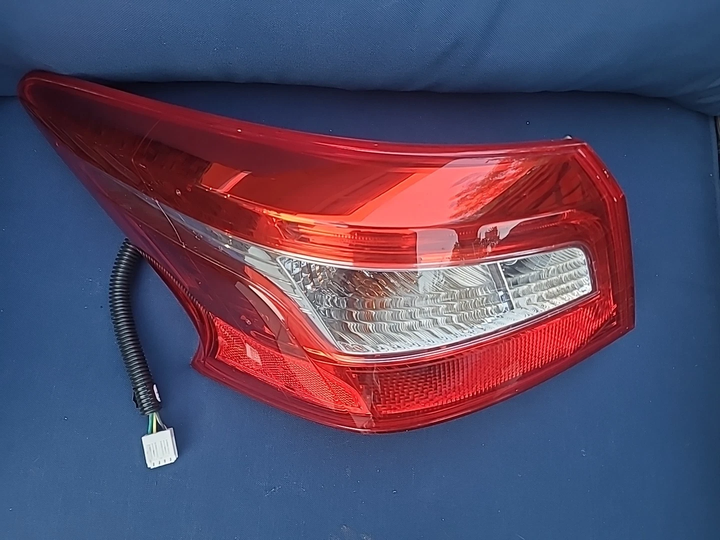 Close-up of a red car tail light with wiring attached.