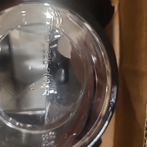 Close-up of a transparent plastic container with a black object inside.