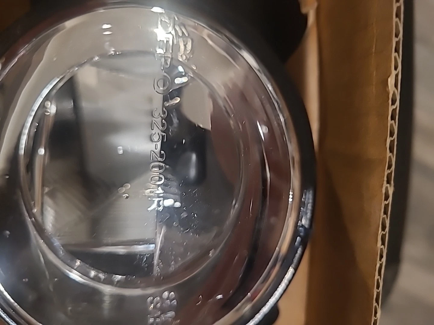 Close-up of a transparent plastic container with a black object inside.