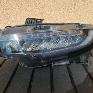 Damaged car headlight with visible cracks and scratches.