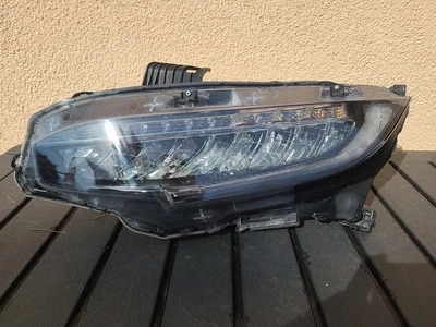Damaged car headlight with visible cracks and scratches.