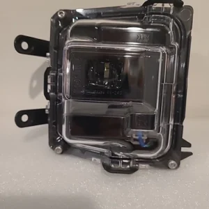 A clear automotive headlight assembly with mounting brackets.